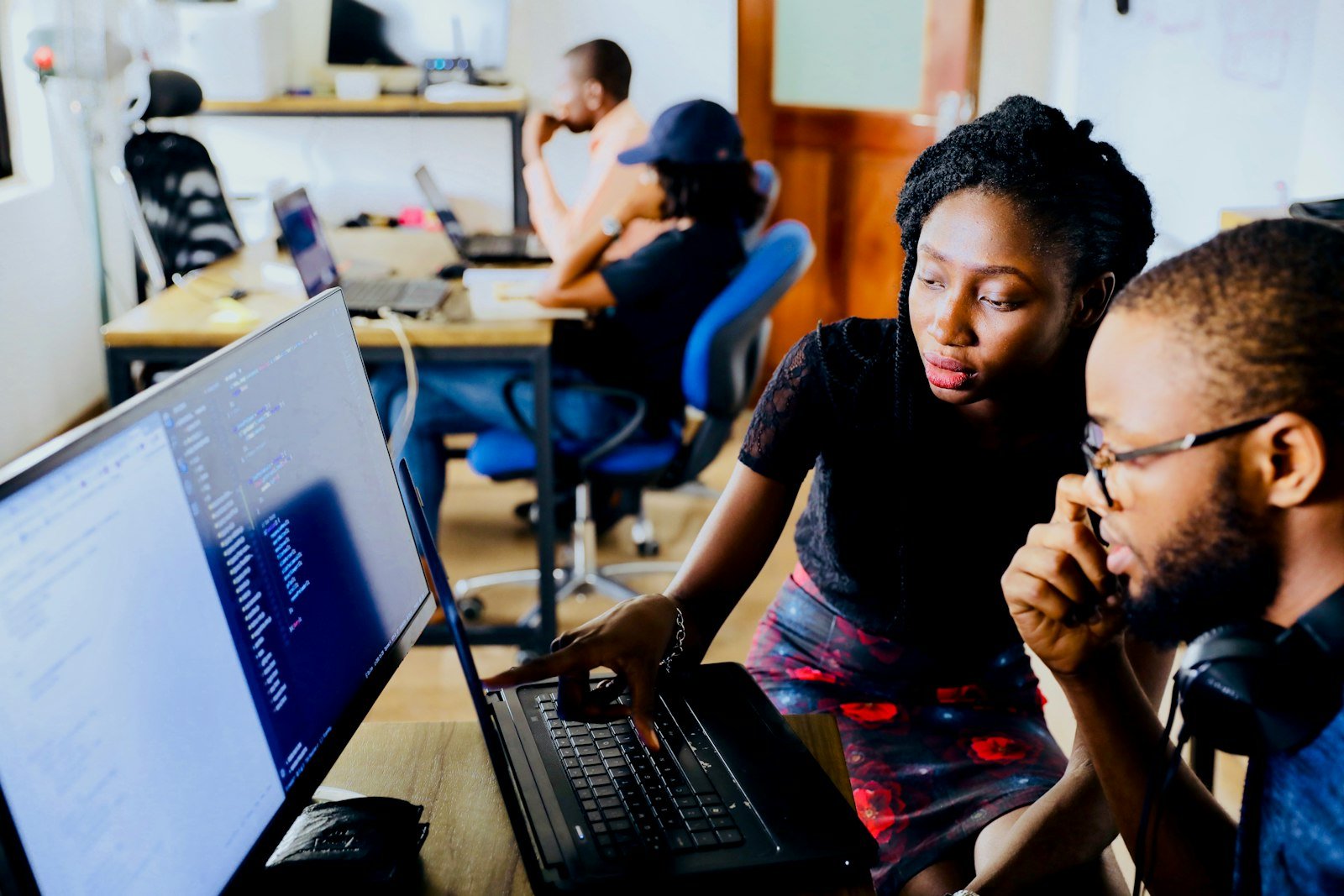 Two software engineers in Lagos collaborating over a laptop